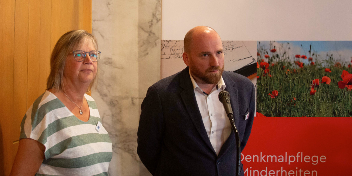 Eine Frau und ein Mann vor Stellwand