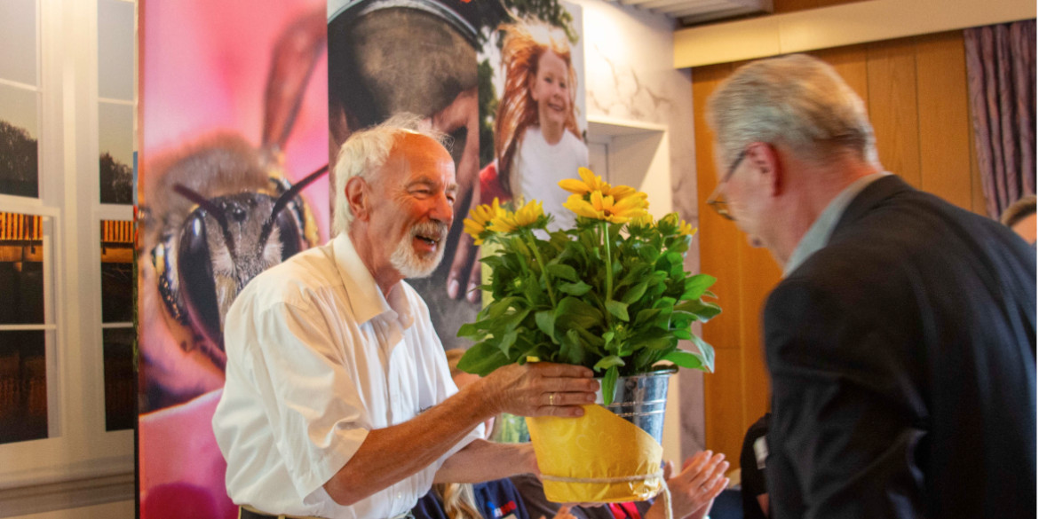 Eine Person bekommt von einer anderen eine Blume überreicht