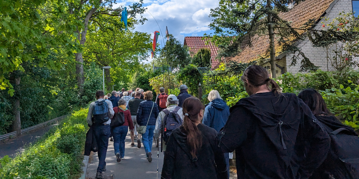 Menschen wandern einen grün bewachsenen Fußweg entlang