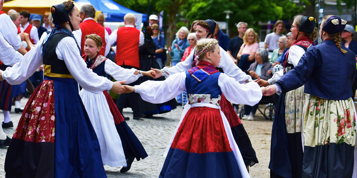 Junge und alte Trachtentänzerinnen im Tanzkreis