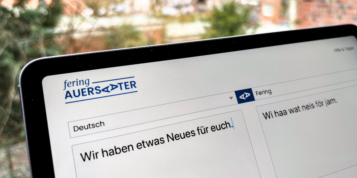 Tablet mit dem Übersetzungstool "Fering Auersaater" und dem Satz "Wir haben etwas Neues für euch"