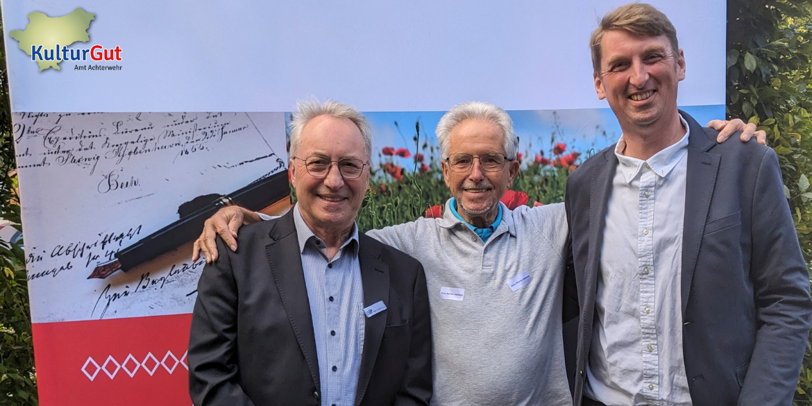 Drei Männer vor Stellwand