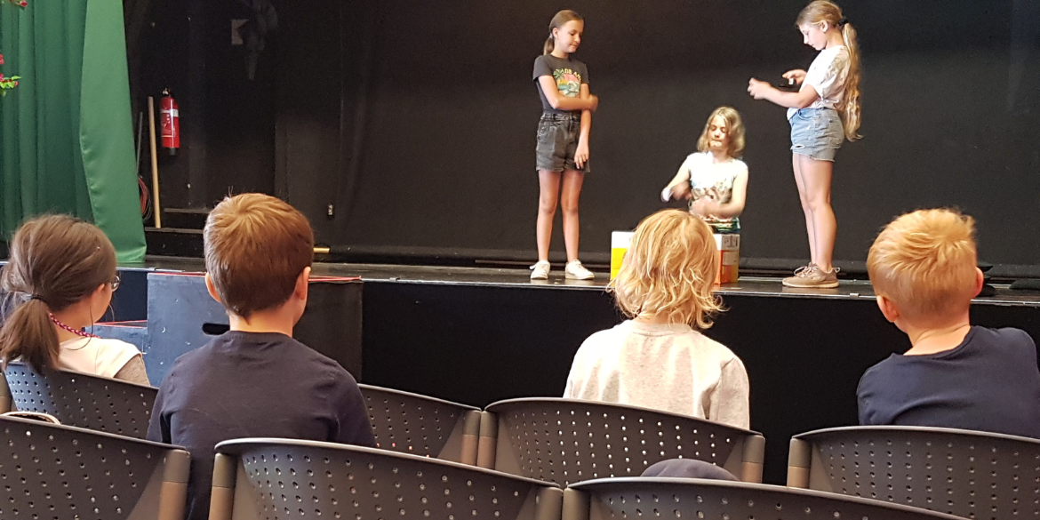 Kinder auf der Theaterbühne und im Zuschauerraum