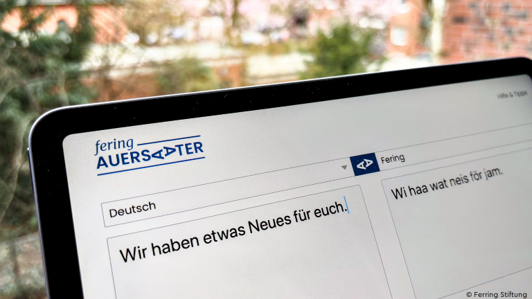 Tablet mit dem Übersetzungstool "Fering Auersaater" und dem Satz "Wir haben etwas Neues für euch"