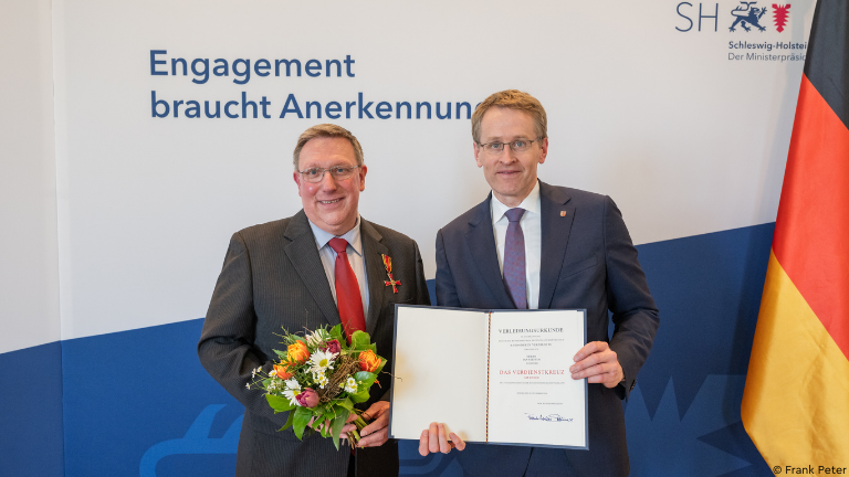 Jan Steffen (li.) und Schleswig-Holstein Ministerpräsident Daniel Günther mit Verdienstkreuz-Urkunde