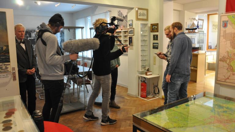Sieben Personen bei Filmaufnahmen in einem Museum