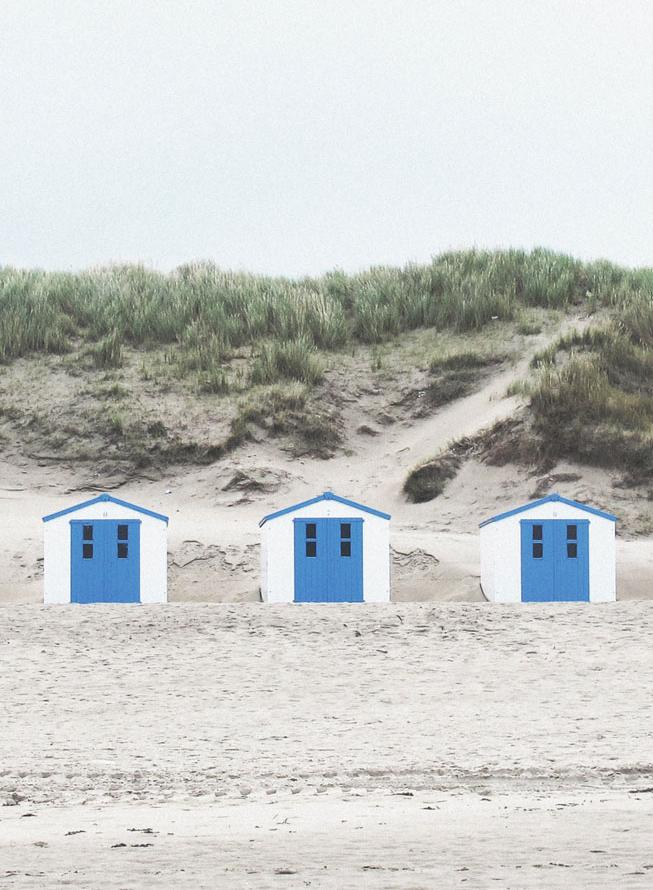 Drei kleine Blockhütten am Strand